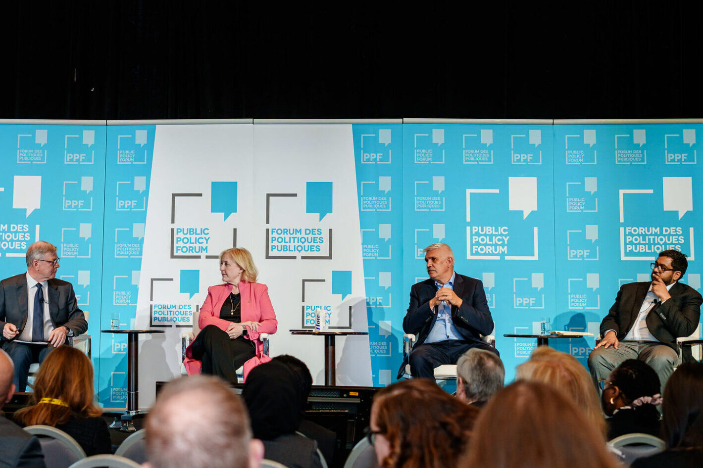 Four people sitting on stage at the Public Policy Forum