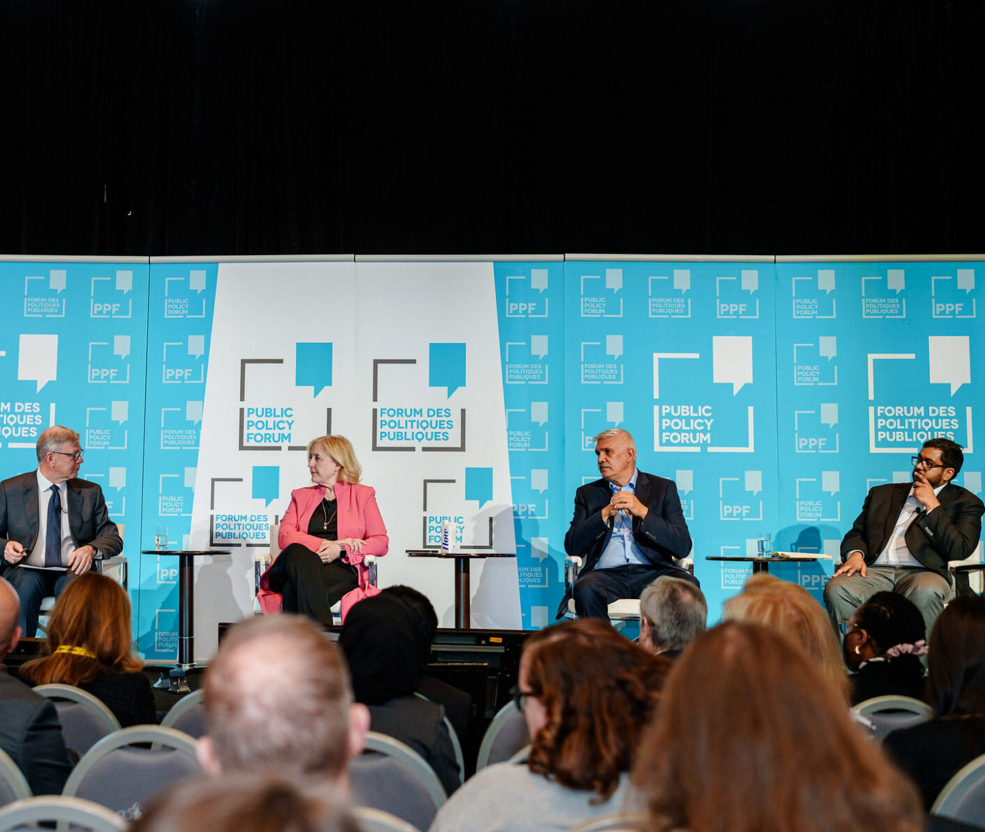 Four people sitting on stage at the Public Policy Forum