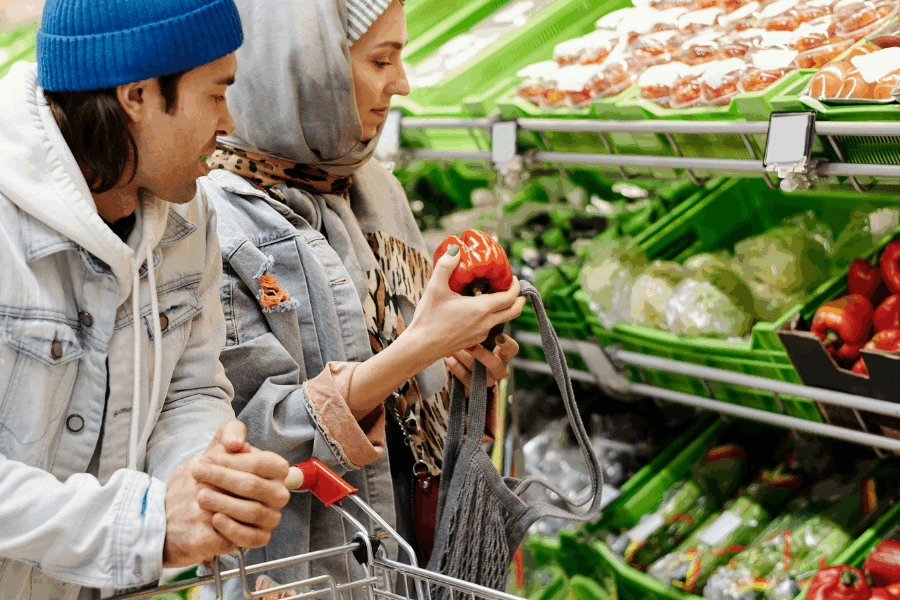 Man and woman buy vegetables at the grocery store