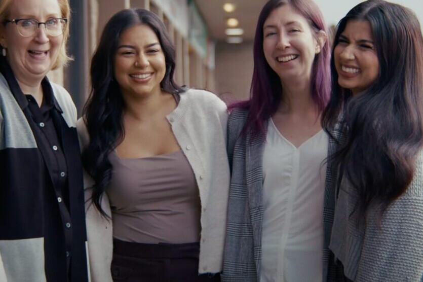 Taproot employees smiling with arms around each other