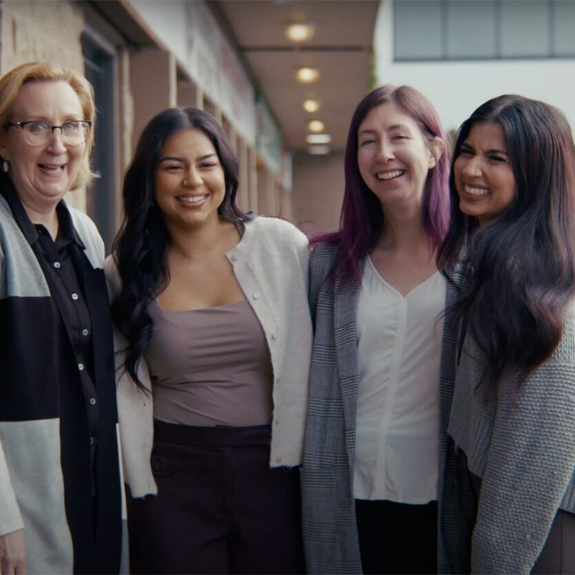 Taproot employees smiling with arms around each other