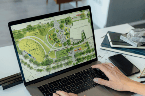 map showing on open laptop computer with hands typing